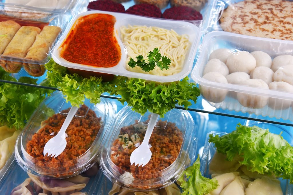A variety of prepackaged food products in plastic boxes.