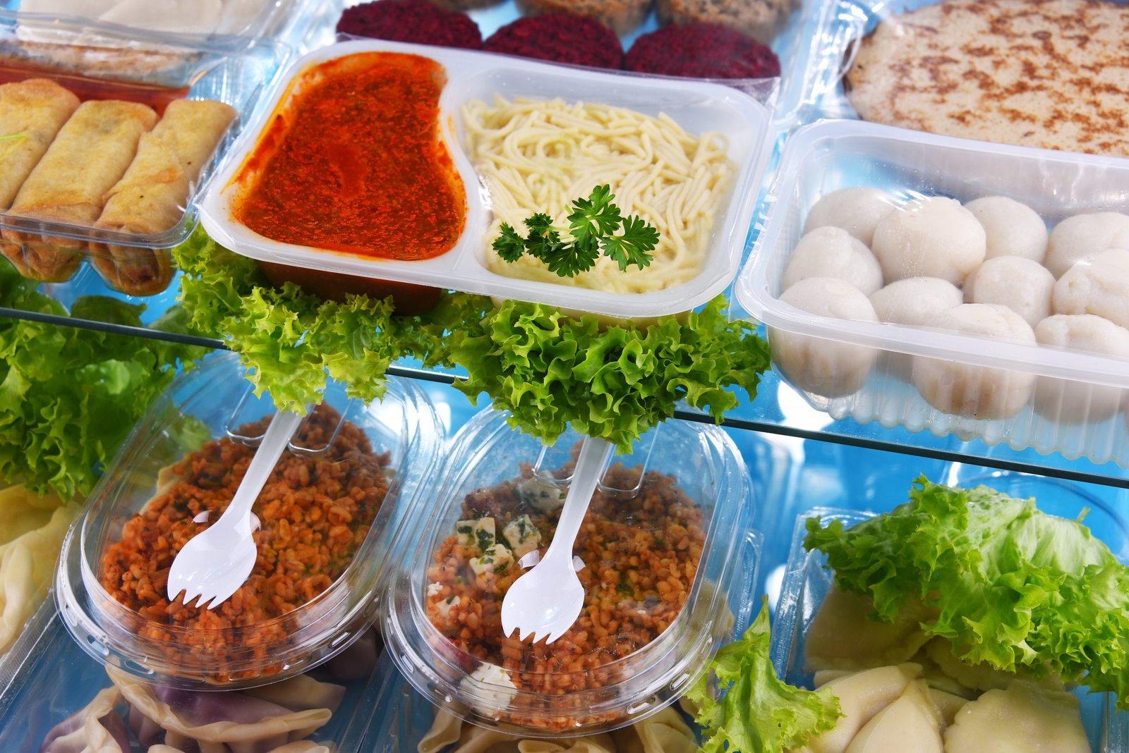 A variety of prepackaged food products in plastic boxes. scaled